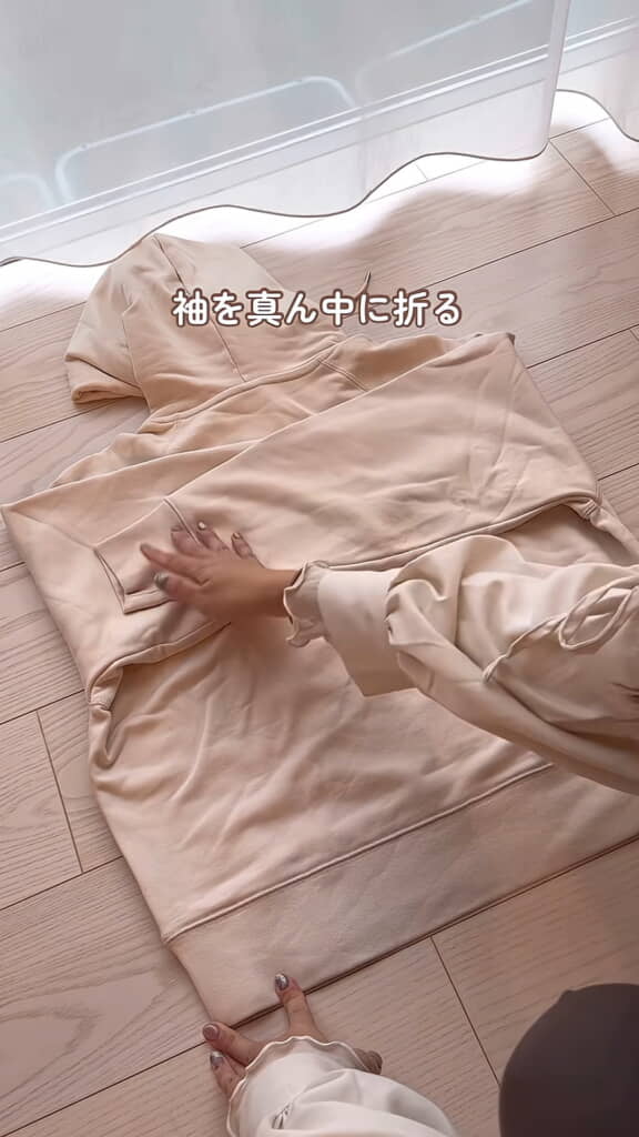 まずは袖を真ん中に折って……