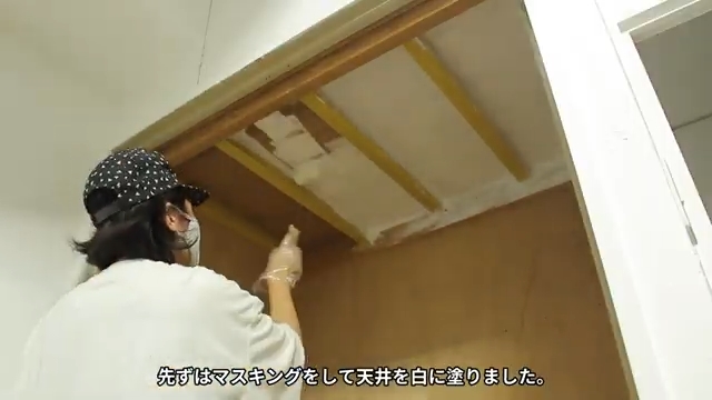 押し入れの天井をローラーで白く塗っている