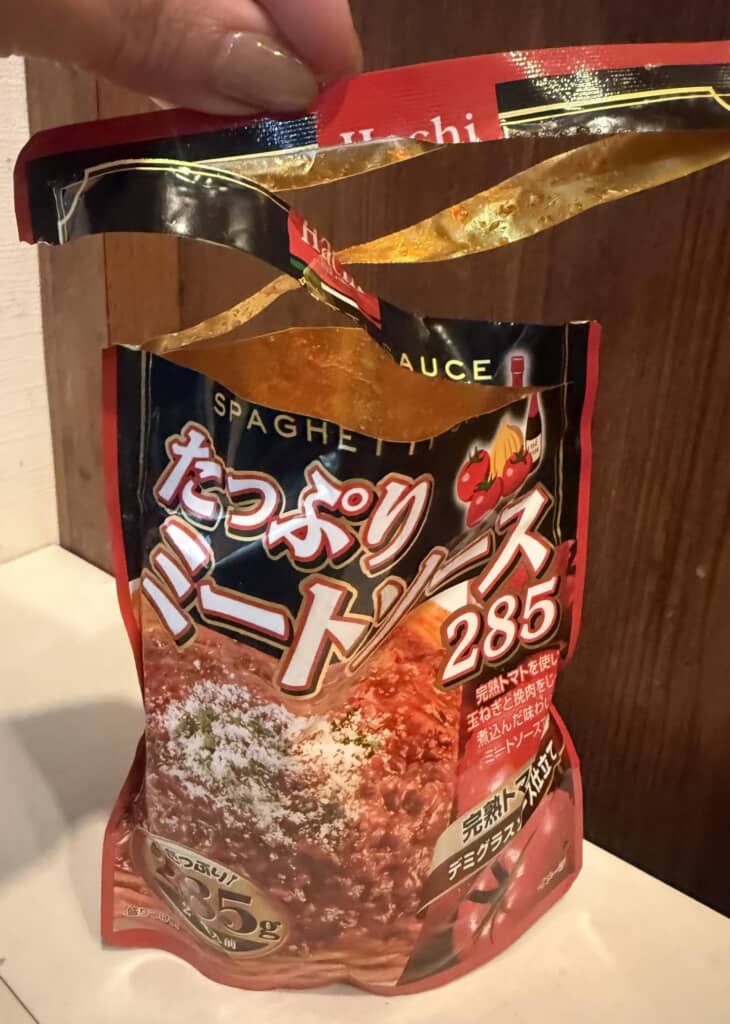 開封途中で中身が見えている「たっぷりミートソース285」のパッケージ