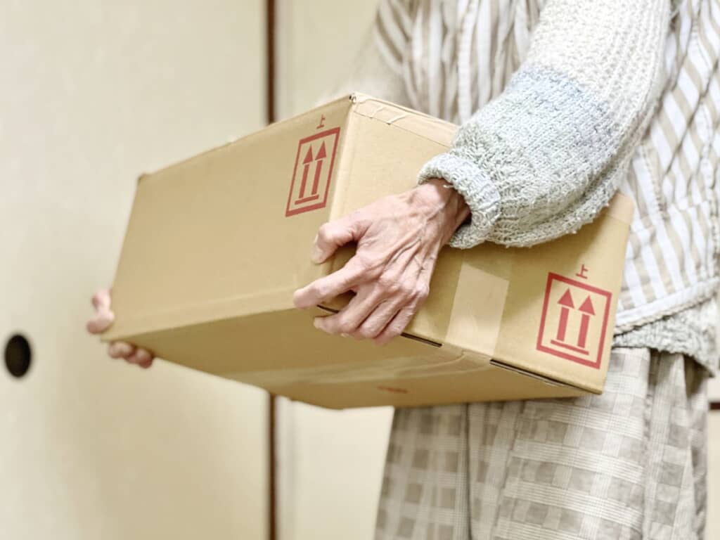 段ボール箱を持ち運んでいる人の写真