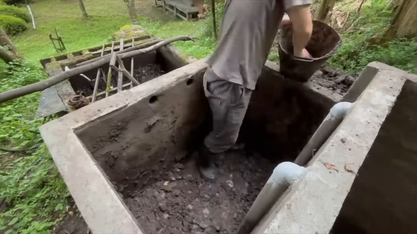 ろ過水槽にたまった泥を取り除く様子