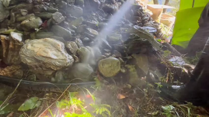 高圧洗浄機から出た水で石を洗う様子