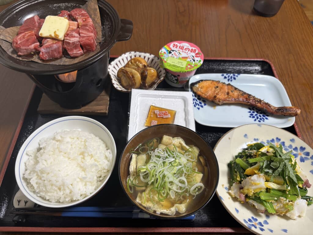 土鍋で焼く牛肉、焼き魚やご飯が並ぶ和定食