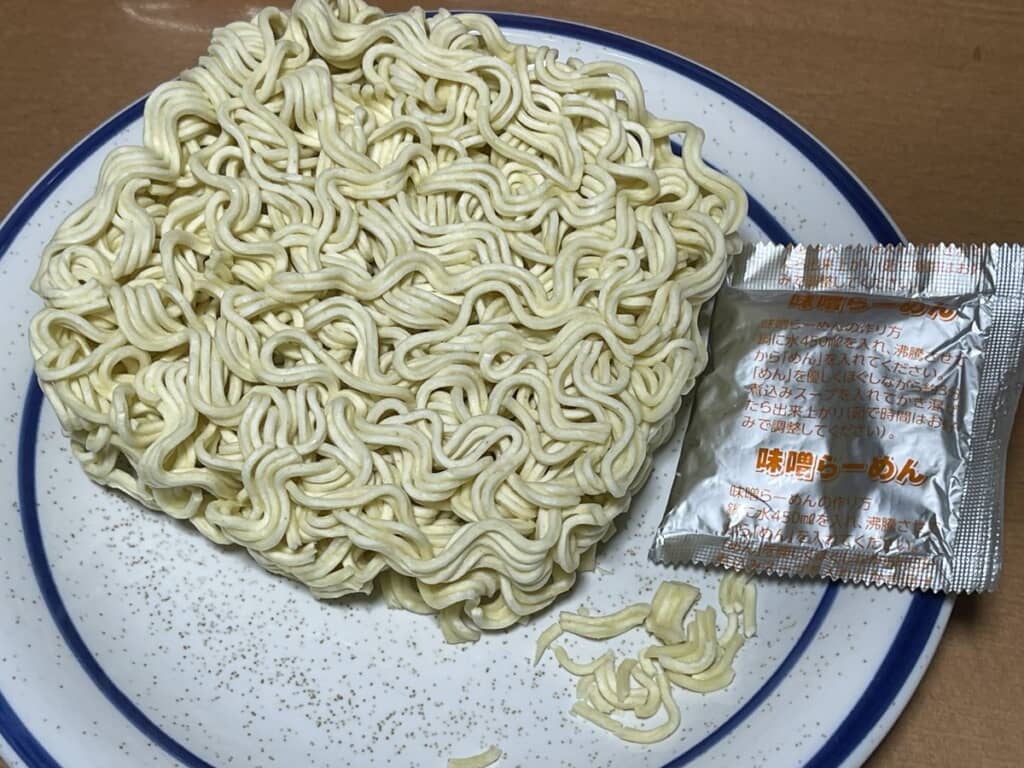 皿にのせた乾麺と味噌ラーメンスープ