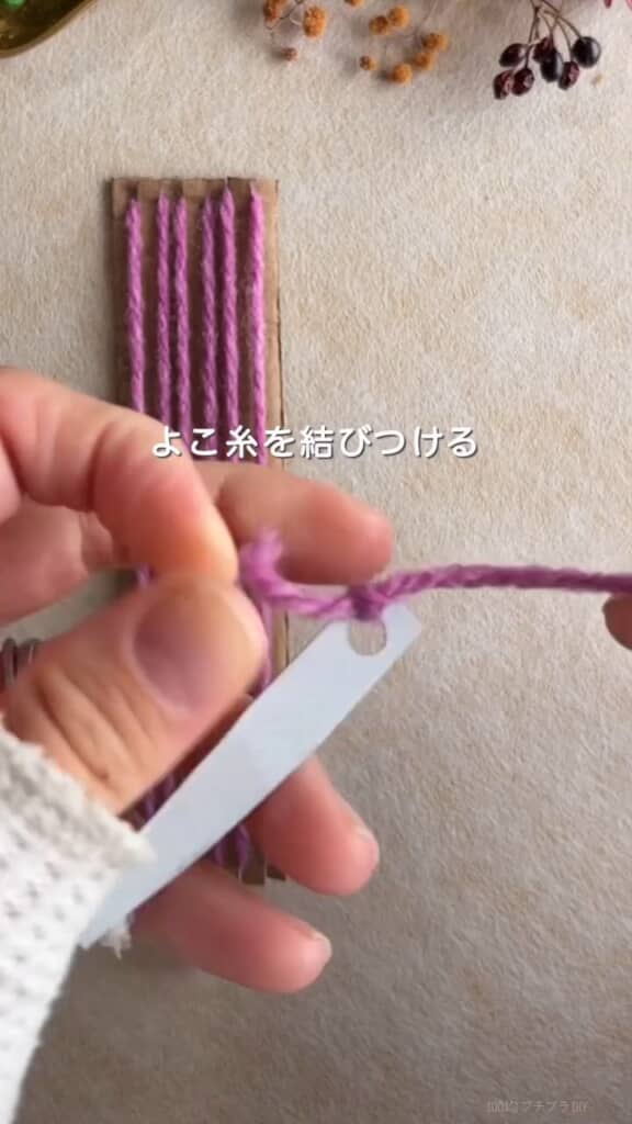 細長く切った厚紙に穴を開けて針代わりに