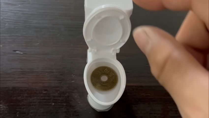 ミニチュアトイレ内に張ったクエン酸水溶液に5円玉を浸す
