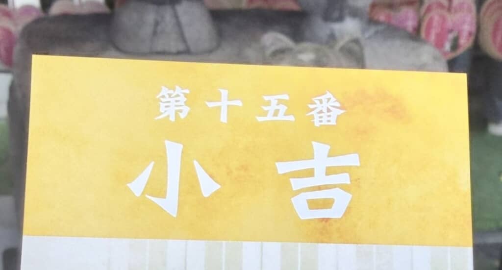 黄色の背景に「第十五番　小吉」と書かれたおみくじ