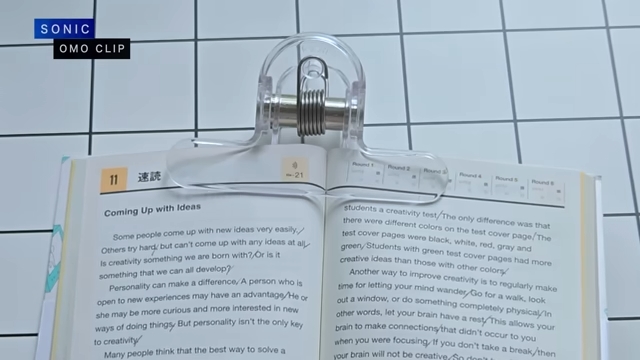 大きなクリップでテキストを開いた状態で留めている