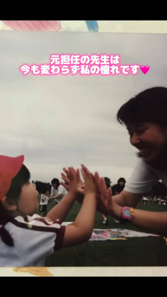 幼稚園時代に担任の先生とハイタッチする様子