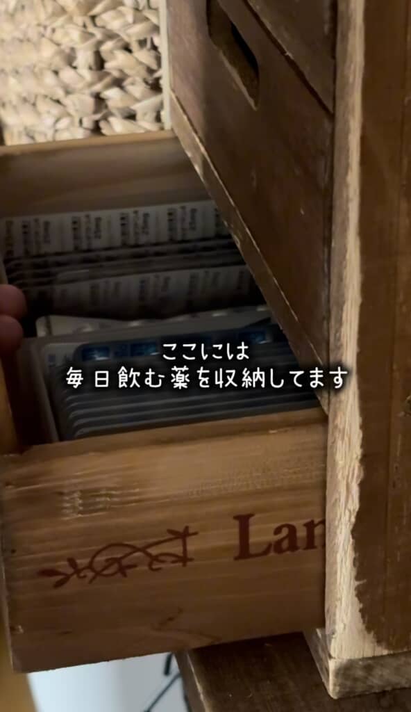 木箱の引き出しに薬のシートを収納している様子