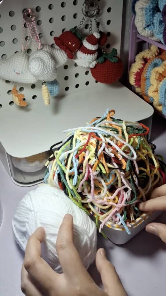 白い毛糸玉と、カラフルな毛糸の切れ端を用意