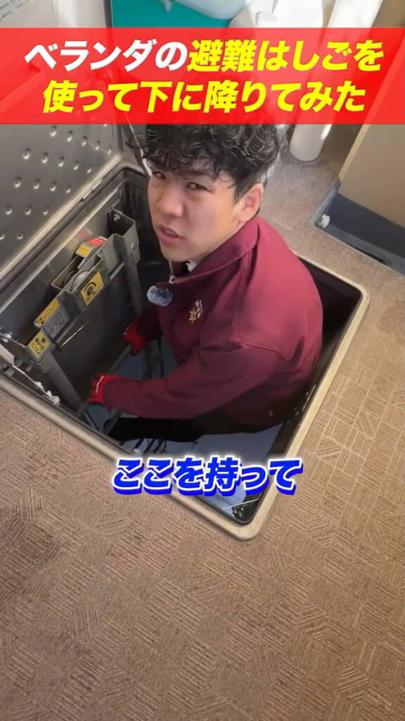 はしご最上段をつかみ……