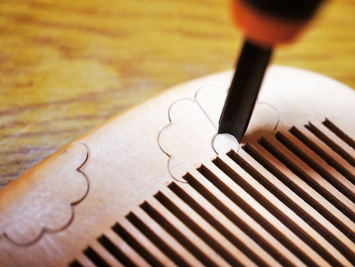 まっさらな木ぐしに模様を彫って……