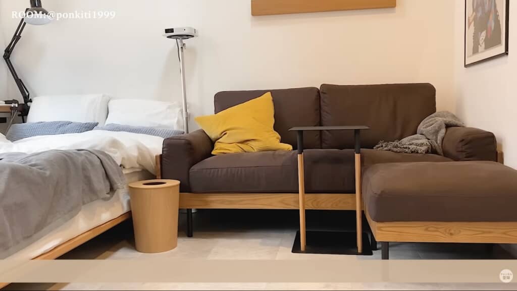 ベッド、ソファ、サイドテーブル、ゴミ箱は同じ色味の木目で統一