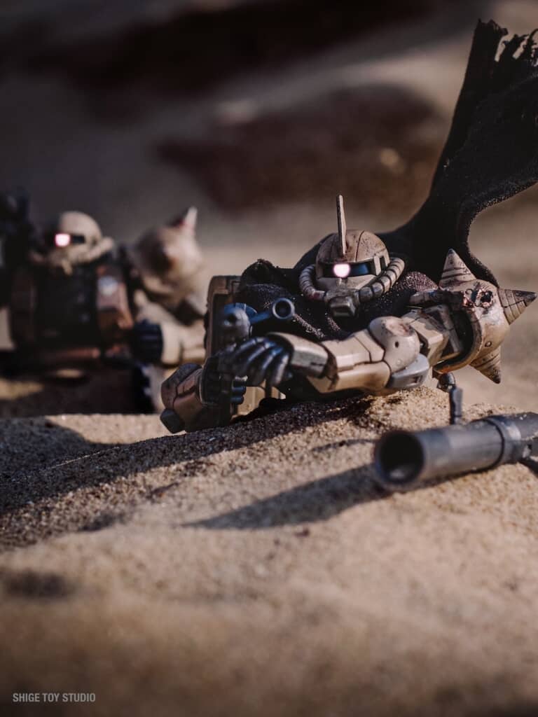 砂から上半身を出している2機のザク