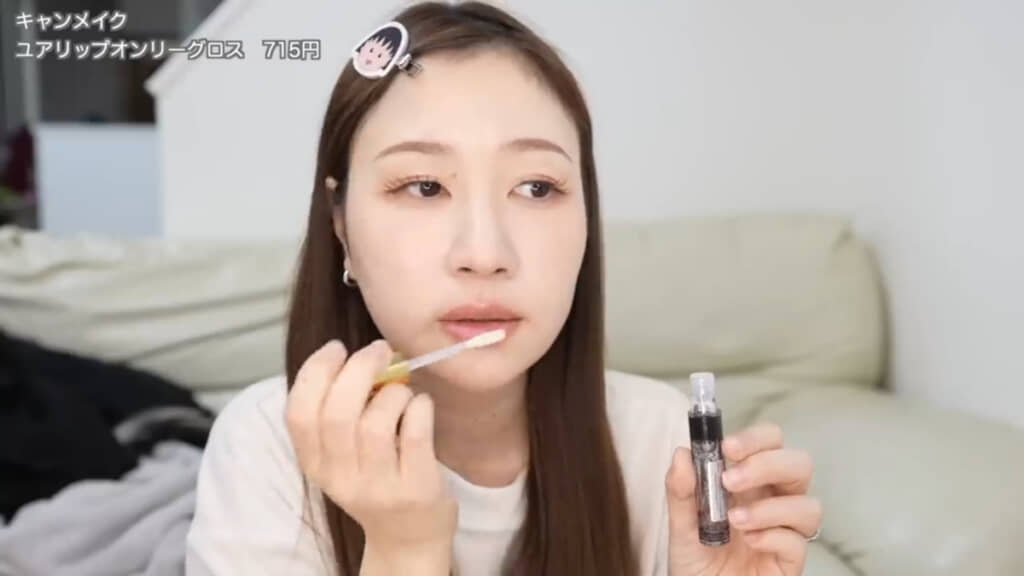 グロスを唇の上下の真ん中に塗る様子