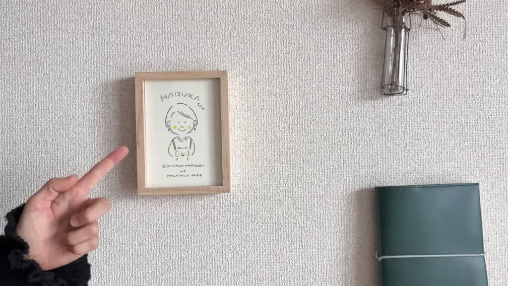 テーブル横の壁には自身の似顔絵