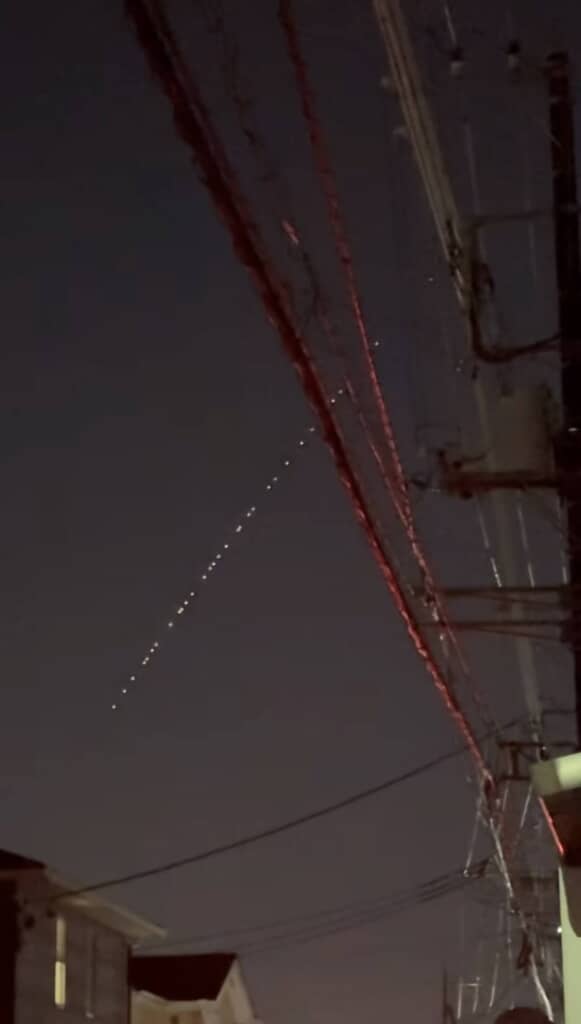 夜空に点々と連なる光と電線