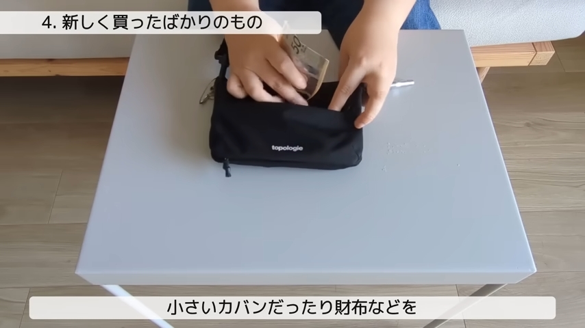 黒い小さなポーチから紙幣を出している