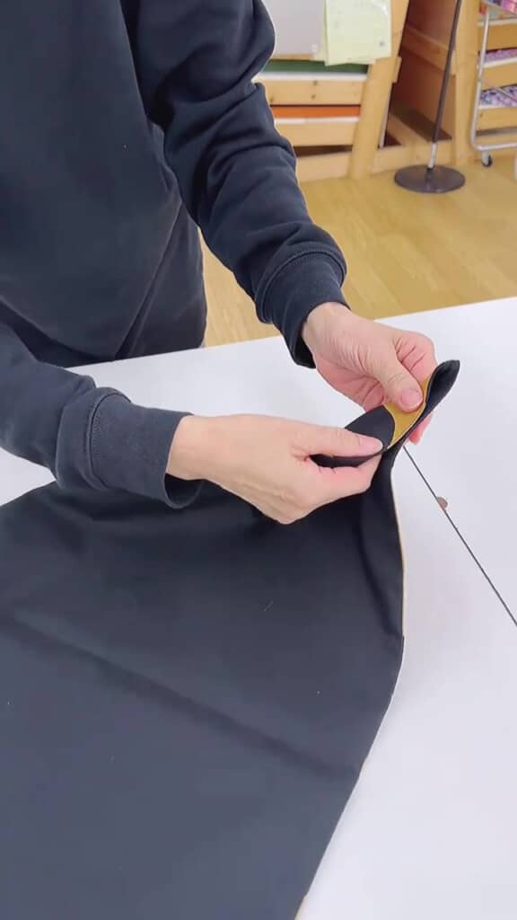 布の隅を折る人の手元