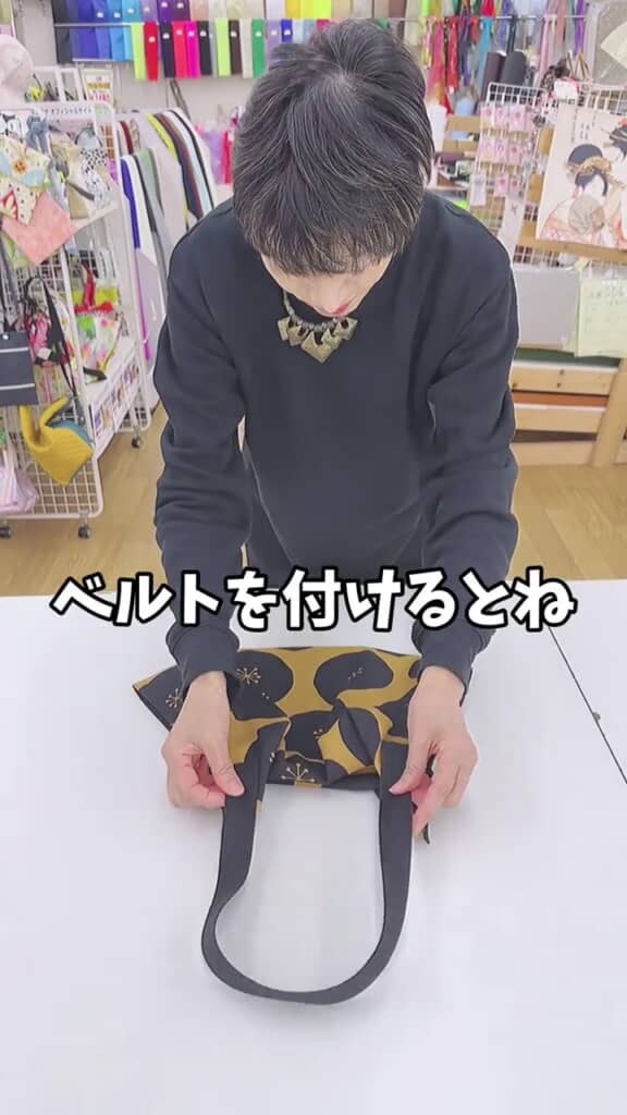 ベルトをバッグに取り付けようとする人