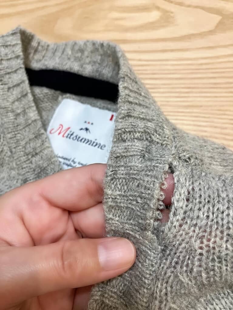 首元がほつれてしまっているセーター