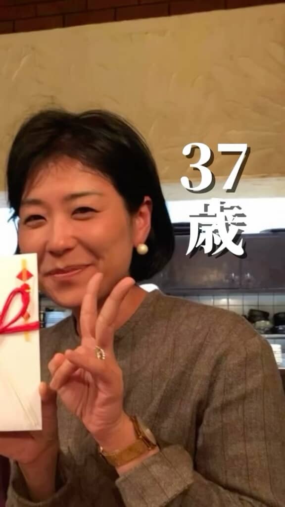 笑顔でピースをする37歳の大谷さん。どこか気を張っているような雰囲気