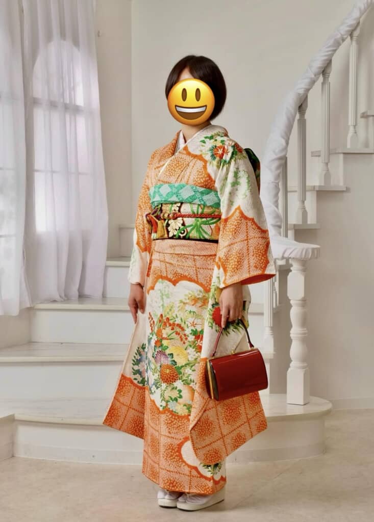 華やかなオレンジ色の振袖に帯がぴったりです