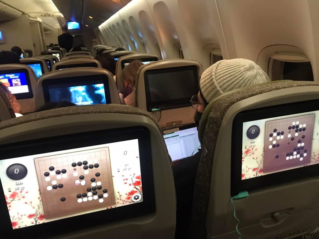 エバー航空の機内でディスプレイを通じて隣の客と囲碁を楽しむ様子