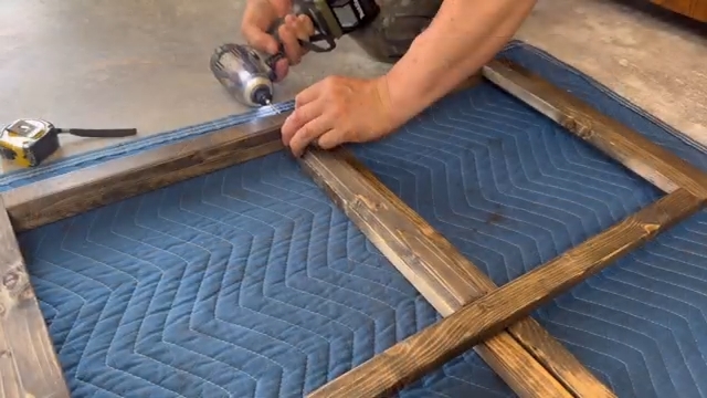 塗装した木材を組み合わせて窓枠を作っている