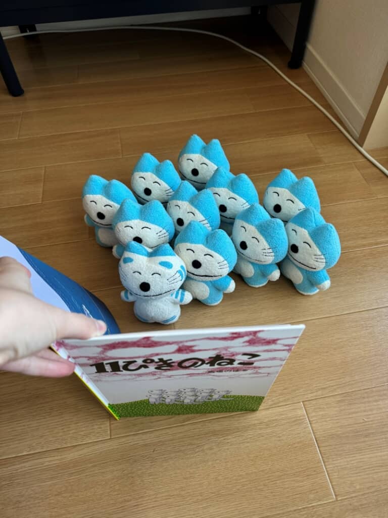 絵本を読み聞かせてもらっている11匹のねこ