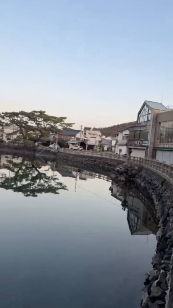 建物や山に囲まれた、どこにでもありそうな池