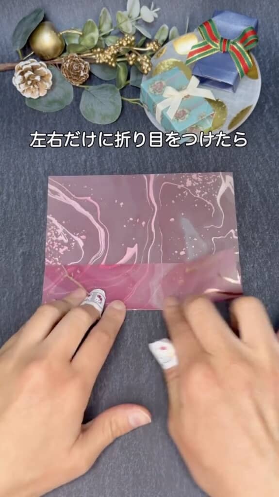 使用するのは1枚の折り紙だけ。まず半分に折り、左右の端だけに折り目を付けます