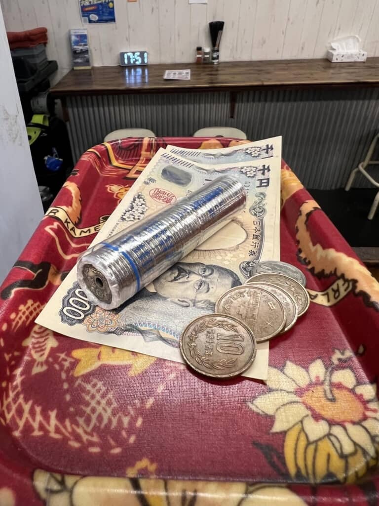 たこ焼き店での会計で紙幣および硬貨と一緒に使われた50枚の50円玉がまとまっている棒金