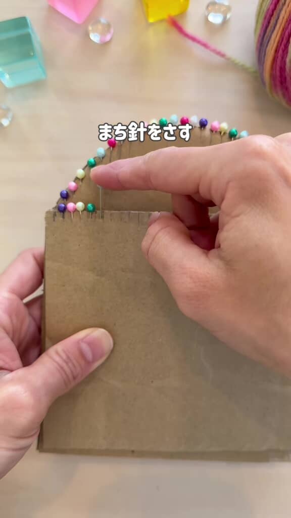 ダンボールの縁に等間隔で待ち針を刺しているところ