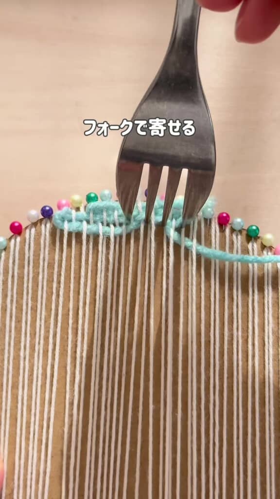 フォークやとじ針で糸を織り込んでいる様子