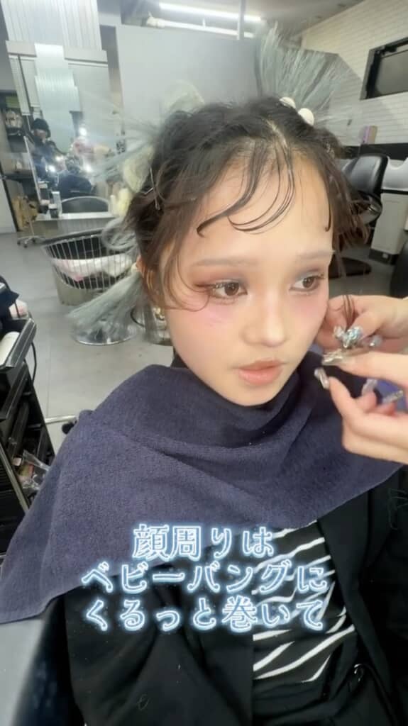 前髪はくるっと巻いた「ベビーバング」に。ヘアアレンジと同時にメイクも行います
