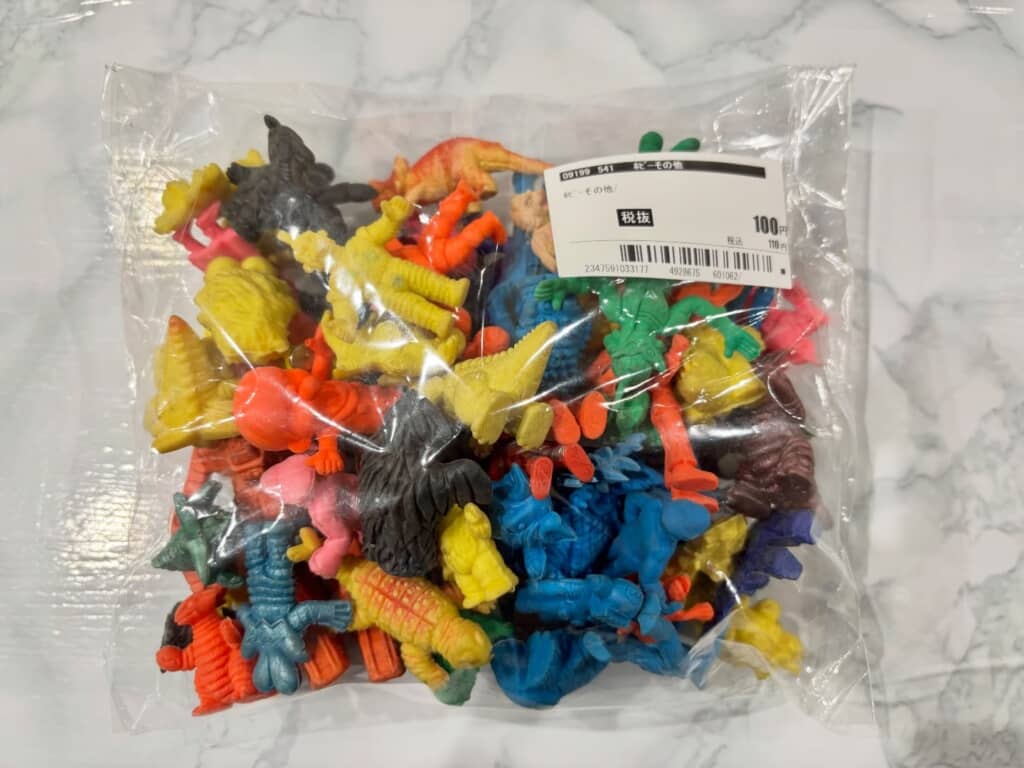 カラフルな怪獣や人形の消しゴムが袋詰めされた写真