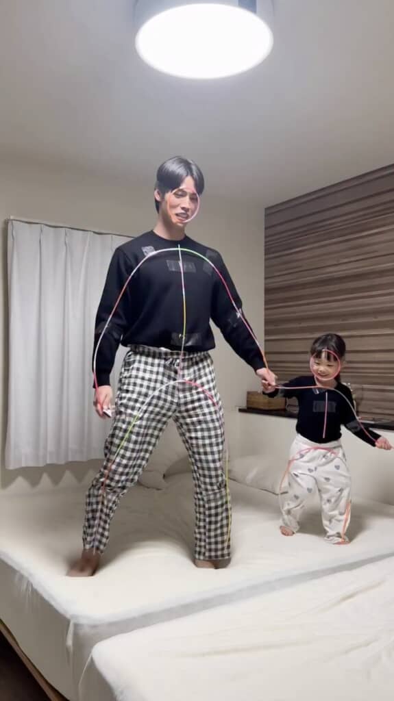 全身にカラフルなパイプを付けた親子