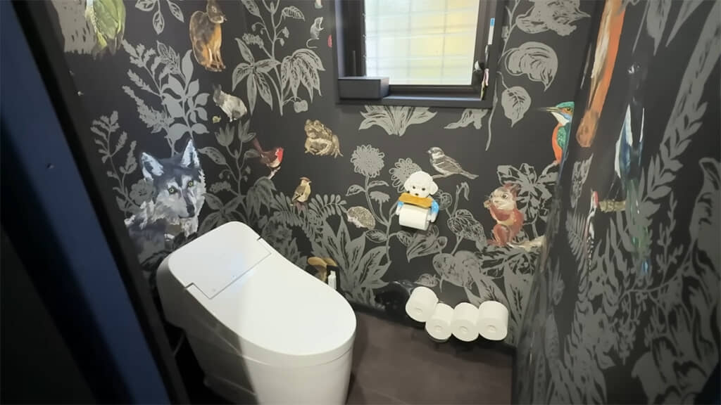 森の動物が描かれた壁紙が素敵なトイレ