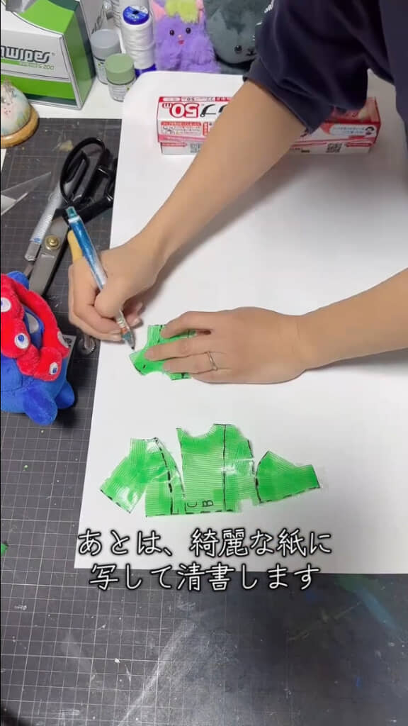 ぬいぐるみから外して平面状にしたテープを紙に写して清書