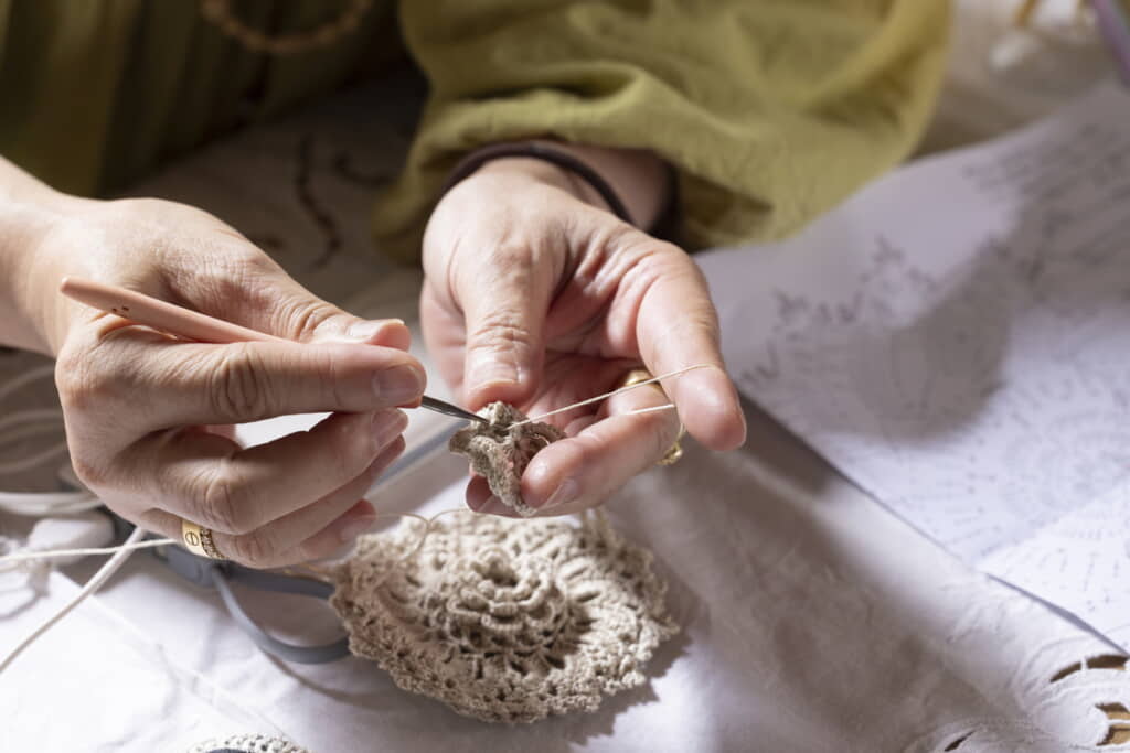 2歳娘にベストを編んでいたママさん（出典：PIXTA）