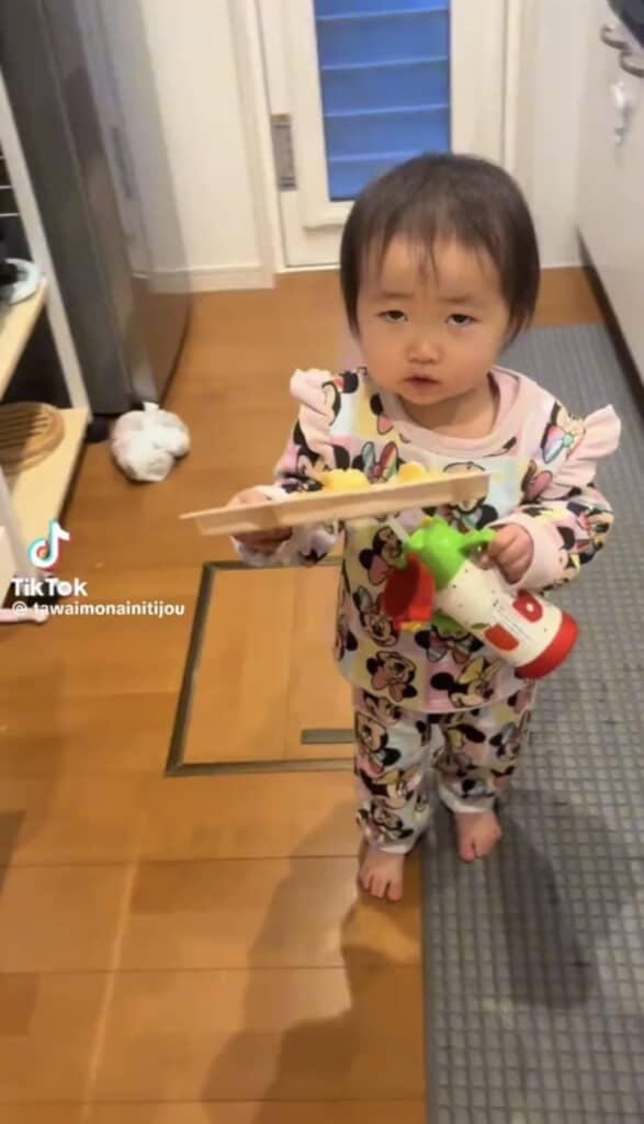 料理を持って歩く1歳女の子