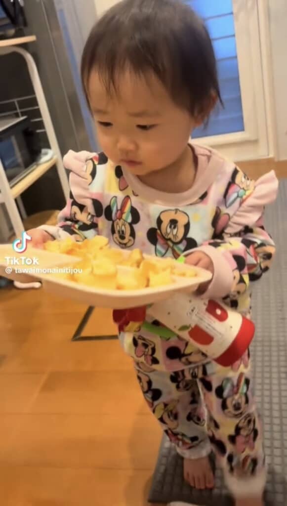 料理を持って歩く1歳女の子