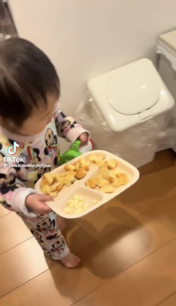 料理を持って歩く1歳女の子