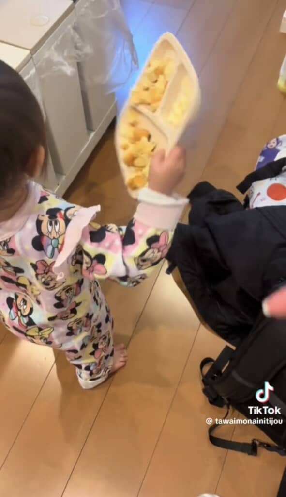 料理を持って歩く1歳女の子