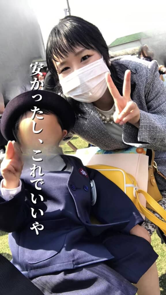 子どもと記念撮影するスーツ姿の投稿者