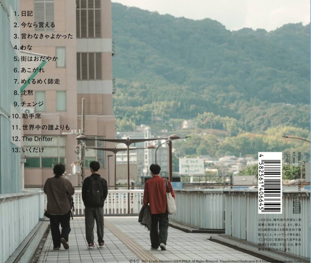 ゴリラ祭リーズ 3rdアルバム『The Drifter』のCDジャケット(裏)。歩道橋のよな場所を歩いているメンバー3人の後ろ姿が写っている。左上には曲名が、右下にはバーコードが記載されている。