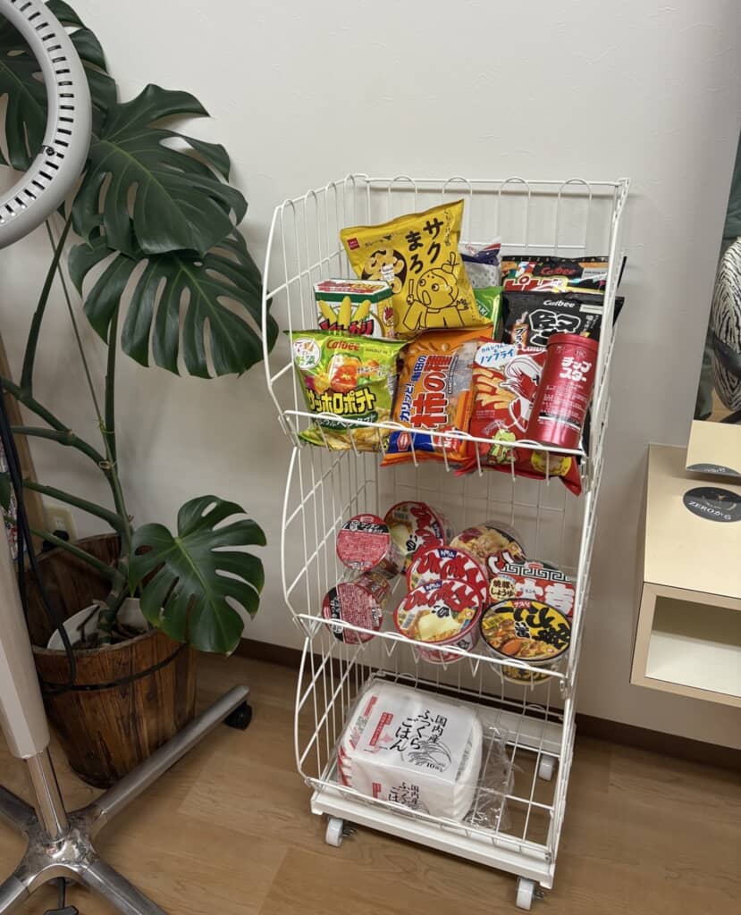 ゲオで購入した3段ワゴンに菓子やカップ麺、ごはんパックなどを積んだ様子