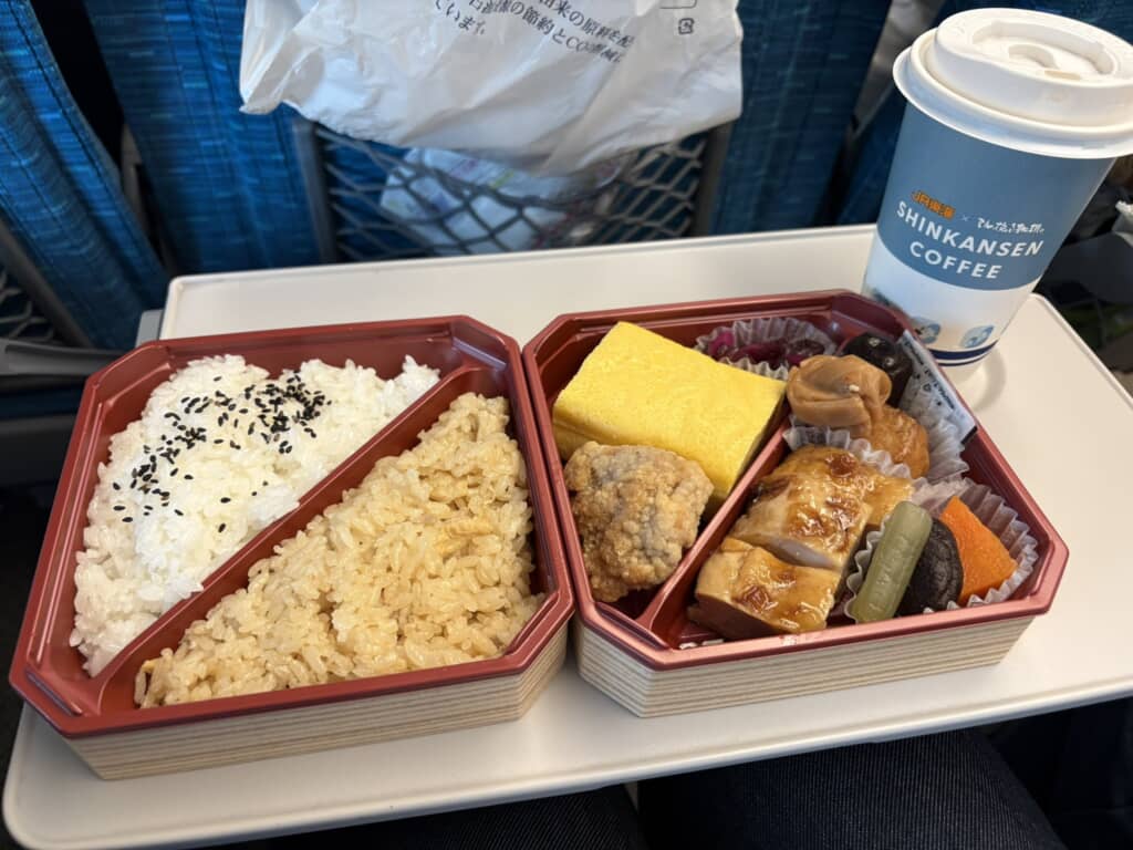 二段重の駅弁と新幹線コーヒーの食事風景